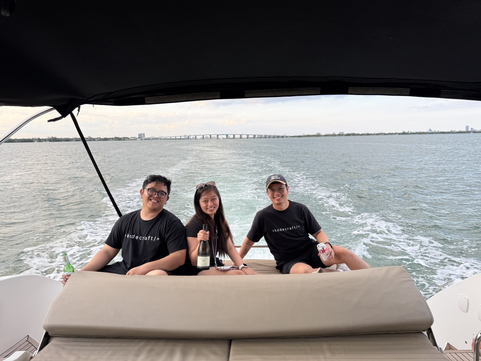 Three teammates seated together on a boat in Miami
