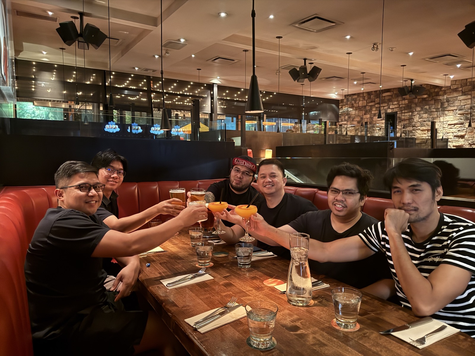 Teammates raising their glasses over dinner at a restaurant