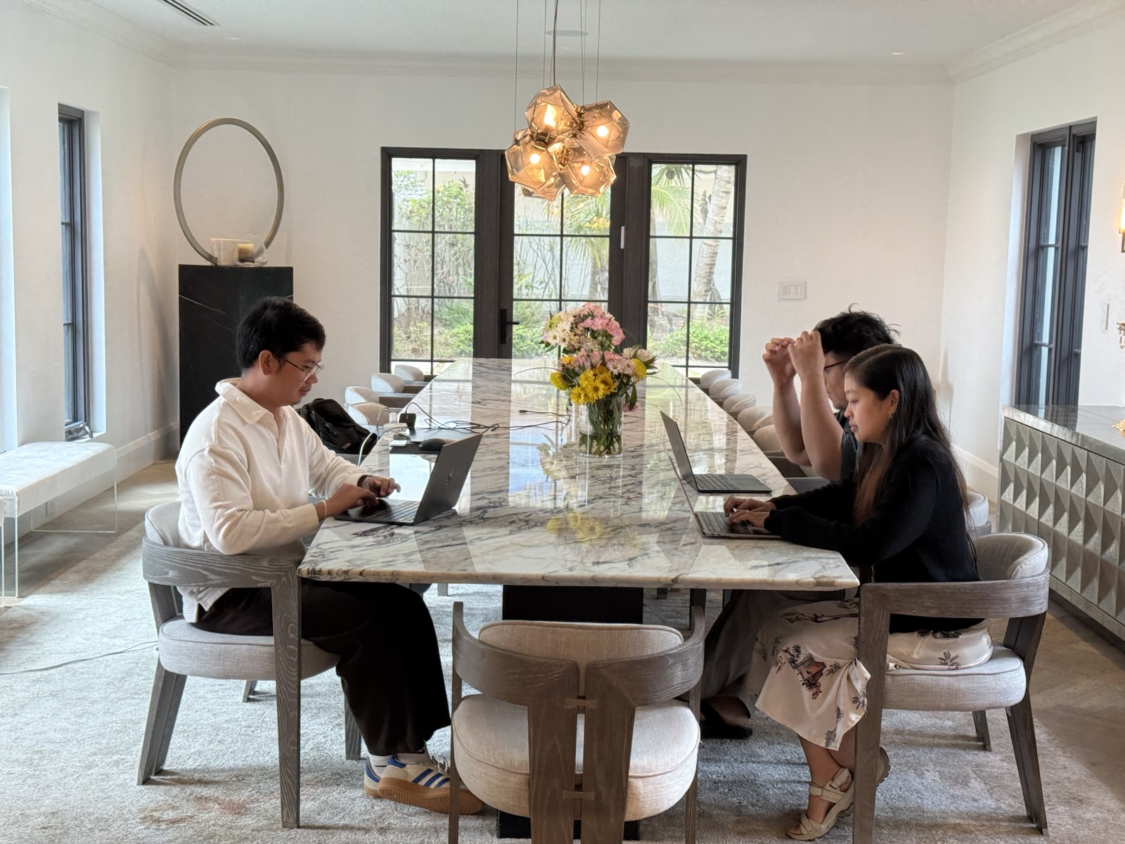 Teammates working on laptops across a large shared table